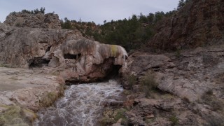 DX0002_129_001 - 5.7K aerial stock footage of rapids flowing through a rock formation in the mountains of New Mexico