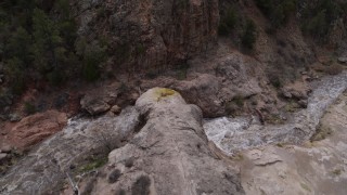 DX0002_129_004 - 5.7K aerial stock footage circling above river rapids flowing through a rock formation in the mountains in New Mexico
