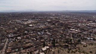 DX0002_129_020 - 5.7K aerial stock footage reverse view of the downtown area and surrounding city of Santa Fe, New Mexico