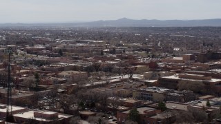 DX0002_129_031 - 5.7K aerial stock footage flying by Radio Plaza for a view of the city's downtown area, Santa Fe, New Mexico