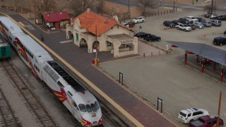 DX0002_130_018 - 5.7K aerial stock footage orbit passenger train at the station in Santa Fe, New Mexico, tilt to top of the train