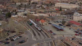 DX0002_130_019 - 5.7K aerial stock footage fly away from passenger train at the station in Santa Fe, New Mexico, tilt to top of the train