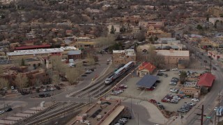 DX0002_130_022 - 5.7K aerial stock footage fly around a passenger train at a station in Santa Fe, New Mexico, tilt to top of the train