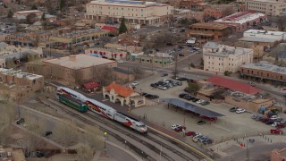 DX0002_130_023 - 5.7K aerial stock footage approach and tilt to a passenger train at a station in Santa Fe, New Mexico, tilt to top of the train