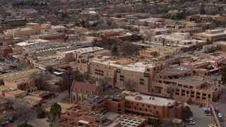 DX0002_130_032 - 5.7K aerial stock footage descend past two hotels in Santa Fe, New Mexico