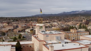 DX0002_131_011 - 5.7K aerial stock footage orbiting tower and flags on Bataan Memorial Building, Santa Fe, New Mexico