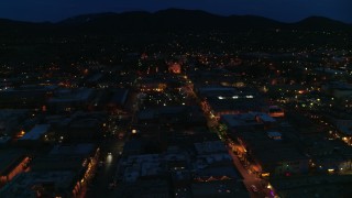 DX0002_132_018 - 5.7K aerial stock footage ascend by downtown, reveal San Francisco Street leading to cathedral at night, Santa Fe, New Mexico
