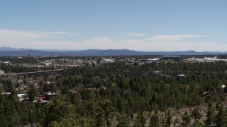 DX0002_134_007 - 5.7K aerial stock footage rising from behind trees, reveal Los Alamos National Laboratory, New Mexico