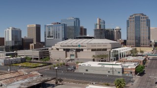 DX0002_136_014 - 5.7K aerial stock footage of a slow reverse view from the arena near office buildings in Downtown Phoenix, Arizona