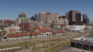 DX0002_136_018 - 5.7K aerial stock footage of flying near a train station and focus on skyline of Downtown Phoenix, Arizona