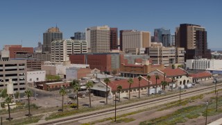 DX0002_136_019 - 5.7K aerial stock footage approach a train station with city skyline behind it in Downtown Phoenix, Arizona