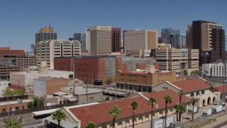 DX0002_136_020 - 5.7K aerial stock footage of a reverse view of a train station and city skyline of Downtown Phoenix, Arizona