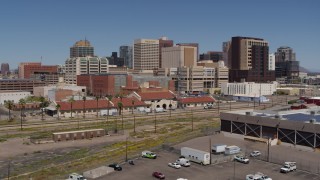DX0002_136_021 - 5.7K aerial stock footage of a slow pass near a train station, focus on skyline of Downtown Phoenix, Arizona