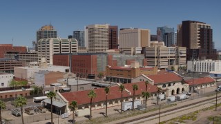DX0002_136_023 - 5.7K stock footage aerial video of flying away from a train station and the city's skyline, Downtown Phoenix, Arizona