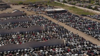 DX0002_136_042 - 5.7K aerial stock footage of flying by cars at an automobile junkyard in Phoenix, Arizona