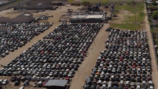 DX0002_136_043 - 5.7K aerial stock footage of passing by rows of cars at an automobile junkyard in Phoenix, Arizona