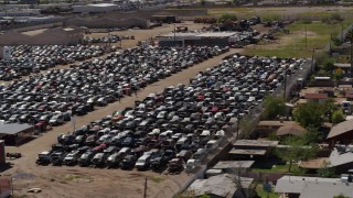 DX0002_136_045 - 5.7K aerial stock footage of flying by urban homes and cars at a junkyard in Phoenix, Arizona