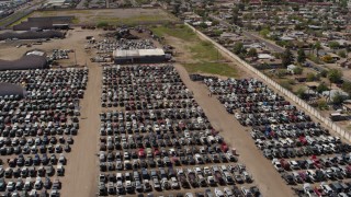 DX0002_137_002 - 5.7K aerial stock footage of orbiting rows of cars at an automobile junkyard in Phoenix, Arizona