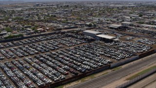 DX0002_137_008 - 5.7K aerial stock footage pass and fly over rows of cars at an automobile junkyard in Phoenix, Arizona