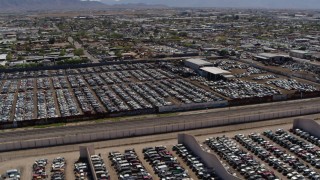 DX0002_137_010 - 5.7K aerial stock footage orbit around rows of cars at an automobile junkyard in Phoenix, Arizona