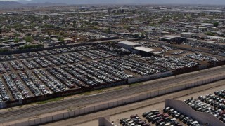 DX0002_137_011 - 5.7K aerial stock footage a stationary view of rows of cars at an automobile junkyard in Phoenix, Arizona