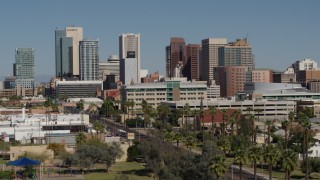 DX0002_137_053 - 5.7K stock footage aerial video of towering office buildings seen from street lined with palm trees in Downtown Phoenix, Arizona