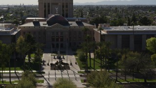 DX0002_137_067 - 5.7K aerial stock footage approach flags in front of the Arizona State Capitol building in Phoenix, Arizona