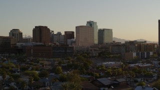 DX0002_138_046 - 5.7K aerial stock footage of a hotel flanked by high-rise office buildings at sunset in Downtown Phoenix, Arizona