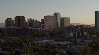 DX0002_138_048 - 5.7K aerial stock footage of reverse view of a hotel and high-rise office buildings at sunset in Downtown Phoenix, Arizona