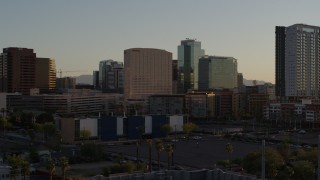 DX0002_138_050 - 5.7K aerial stock footage of flying away from hotel and tall office buildings at sunset in Downtown Phoenix, Arizona