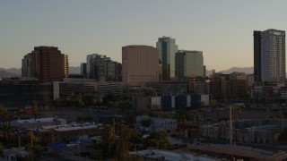 DX0002_138_051 - 5.7K aerial stock footage of passing a hotel and tall office buildings at sunset in Downtown Phoenix, Arizona