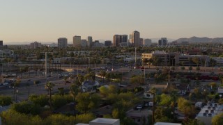 DX0002_138_052 - 5.7K stock footage aerial video of tall office buildings in the distance at sunset in Phoenix, Arizona
