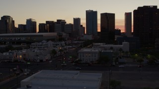 DX0002_139_005 - 5.7K aerial stock footage of passing tall office buildings at sunset, reveal college buildings in Downtown Phoenix, Arizona