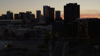 DX0002_139_008 - 5.7K stock footage aerial video of tall office high-rises at sunset seen from busy street in Downtown Phoenix, Arizona