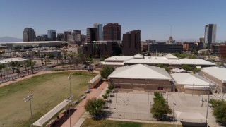 DX0002_140_002 - 5.7K aerial stock footage of orbiting a charter school to reveal city's skyline in Downtown Phoenix, Arizona