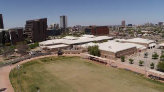 DX0002_140_003 - 5.7K aerial stock footage of orbiting a charter school near the city's skyline in Downtown Phoenix, Arizona