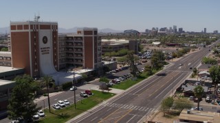 DX0002_140_022 - 5.7K aerial stock footage pan from street and skyline to hospital complex in Phoenix, Arizona
