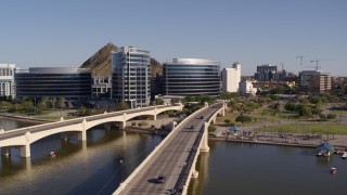 DX0002_142_010 - 5.7K aerial stock footage orbiting waterfront office buildings seen from bridges spanning Tempe Town Lake in Tempe, Arizona