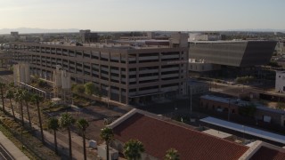 DX0002_142_036 - 5.7K aerial stock footage fly away from and orbit parking garage by the sheriff's office at sunset in Downtown Phoenix, Arizona