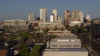 DX0002_143_013 - 5.7K aerial stock footage follow Adams Street toward city's skyline at sunset in Downtown Phoenix, Arizona
