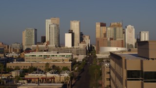 DX0002_143_017 - 5.7K aerial stock footage focus on city's skyline at sunset, flyby rooftop to reveal Adams Street, Downtown Phoenix, Arizona
