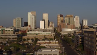 DX0002_143_019 - 5.7K aerial stock footage of Adams Street leading to the city's towering skyline at sunset, Downtown Phoenix, Arizona