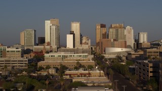 DX0002_143_023 - 5.7K aerial stock footage reverse view of city's skyline and Adams Street at sunset, Downtown Phoenix, Arizona