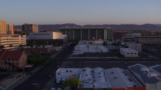DX0002_143_037 - 5.7K aerial stock footage of flying past a performing arts theater, courthouse and TV station at sunset, Downtown Phoenix, Arizona