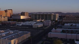 DX0002_143_040 - 5.7K aerial stock footage of passing a performing arts theater, courthouse and TV station at sunset, Downtown Phoenix, Arizona