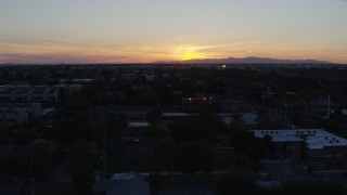 DX0002_143_051 - 5.7K aerial stock footage of the sun setting behind distant mountains, seen from Phoenix, Arizona