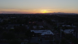 DX0002_143_052 - 5.7K stock footage aerial video of a view of the sun setting behind distant mountains, seen from Phoenix, Arizona