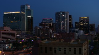 DX0002_143_062 - 5.7K aerial stock footage reverse view of high-rise office buildings, reveal Westward Ho building at twilight, Downtown Phoenix, Arizona