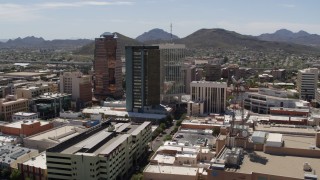 DX0002_144_002 - 5.7K aerial stock footage of ascending past office high-rises, with Sentinel Peak in the distance, Downtown Tucson, Arizona