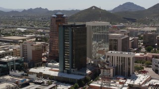 DX0002_144_016 - 5.7K aerial stock footage orbiting three high-rise office towers, revealing "A" Mountain (Sentinel Peak), Downtown Tucson, Arizona